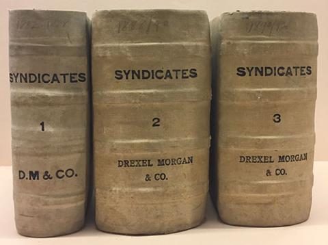 Three thick ledger volumes showing light brown spines with Syndicates and Drexel Morgan & Co. written on them.